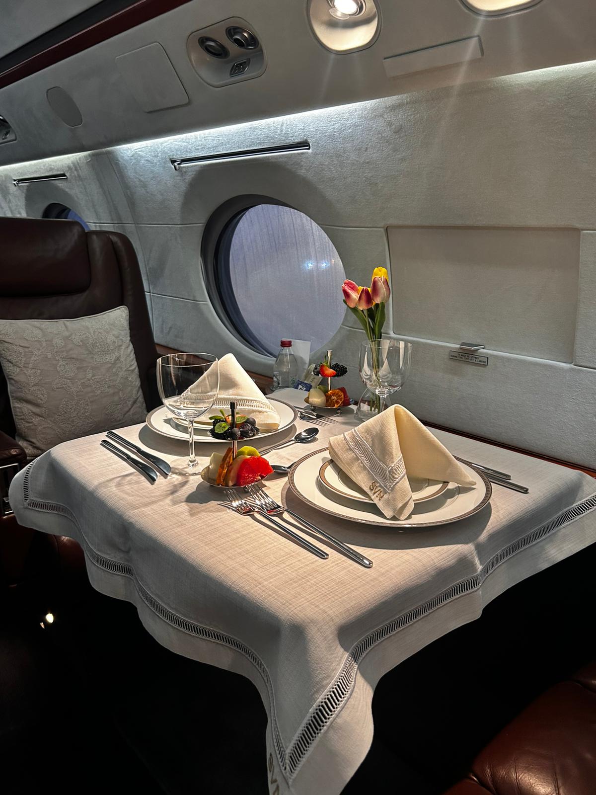 Prepared dining table inside private jet cabin